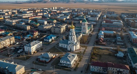 Obraz premium Aerial View of a Cityscape with Church and Distant Mountains