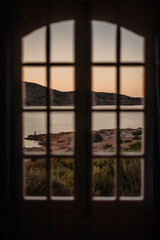 Sunset View Through Window of Coastal Landscape and Lone Figure