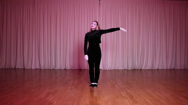 On stage, a mime girl demonstrates a robot, a puppet doll.