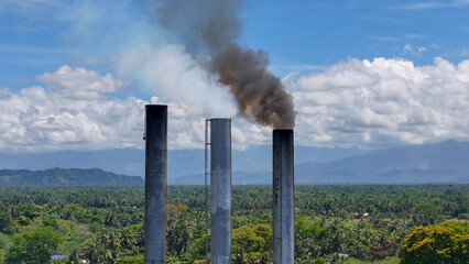 Industrial Smoke Stacks Emitting Plumes Over Butuan Forest Canopy in Mindanao