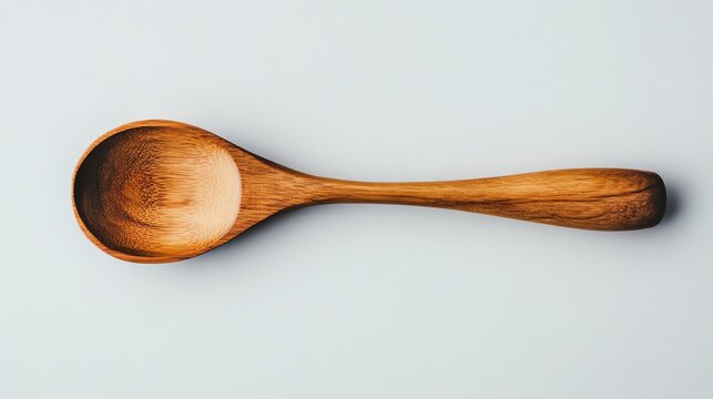 A light gray background showcases a single wooden spoon.