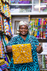 Smiling African woman, successful small business owner of an African Print, Ankara fabric shop...