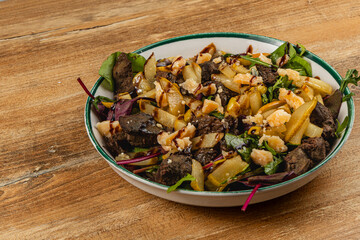 Savory liver salad with fresh greens and nuts served in bowl