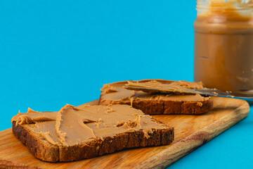 Creamy peanut butter spread on bread with vibrant background