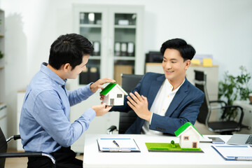 Professional team collaboration in modern office, discussing real estate model and signing contract, concept of startup