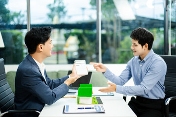 Real estate broker agent presenting and consult to customer to decision making sign insurance form agreement, home model