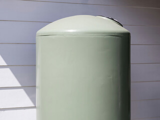 Green Rainwater Retention Tank Installed Beside White Exterior Wall