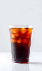 Cola cold drink with ice cubes, in plastic cup, isolated on a white studio background