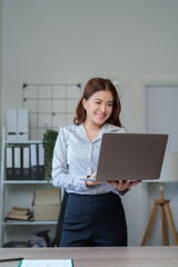 Young asian businesswoman working on laptop in modern office