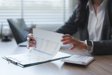 Businesswoman analyzing financial charts and data in office setting
