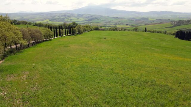 Italy, Tuscany, 05,23,25 the famous winding road with cypress trees close to
 La Foce in Castelluccio Val D'Orcia Tuscan landscape : drone aerial view of Tuscany Apennines and amazing spring nature 