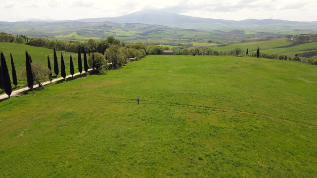 Italy 05,26,25 two tourists make a pilgrimage Cammino degli dei (path of the gods) walking through the Tuscan countryside, Val D'orcia Assisi - view from the drone of the route immersed in lush nature