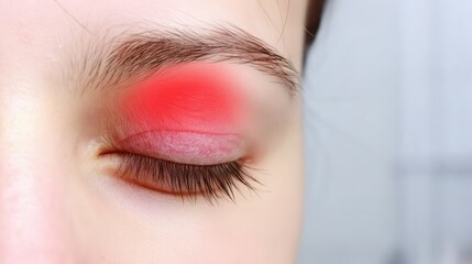 Obraz premium Woman with red irritation in her eye looking in pain on plain white background, symptoms of eye pain, eye scratch or medical eye problems