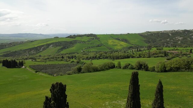 Italy, Tuscany, 05,23,25 the famous winding road with cypress trees close to
 La Foce in Castelluccio Val D'Orcia Tuscan landscape : drone aerial view of Tuscany Apennines and amazing spring nature 