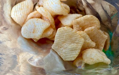 Crispy potato chips, delicious BBQ seasoning spicy for crips, slice deep fried snack fast food in open bag. Chips closeup photo.
