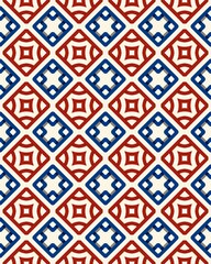 Intricate tiled arrangement of red, blue, and white geometric shapes creates a vibrant surface texture in a lively pattern