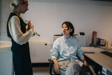 Two colleagues having a thoughtful conversation in a contemporary office space, exuding...