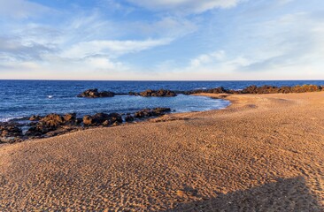 beautiful pink and orange sand beash with black stones and sea surf waves lansacspe with anazing clousy sunset or sunrise sky on background