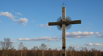Obraz premium Standing Wooden Cross Against Blue Sky in Rural Landscape