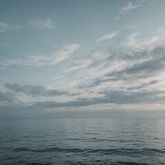 Obraz premium Vast blue sky meets the horizon over the calming sea, where soft clouds drift under the warm summer sun