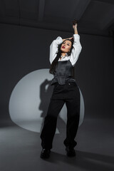 Confident asian woman in black and white fashion outfit posing under dramatic spotlight. Bold red...