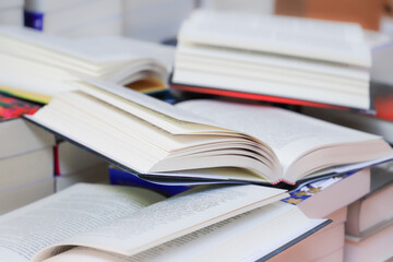 stack of books, close up. Open book on the table in library. Back to school concept.