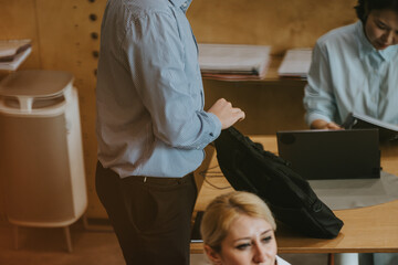 Business environment capturing teamwork and collaboration in a co working setting. People are engaged in various tasks, providing a glimpse into a productive office atmosphere with modern arrangements