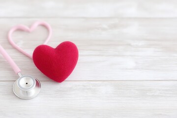 Fototapeta premium Heart with a stethoscope emphasizing health and wellness on a wooden background