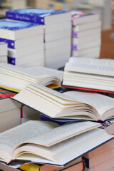 stack of books, close up. Open book on the table in library. Back to school concept.