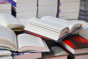 stack of books, close up. Open book on the table in library. Back to school concept.
