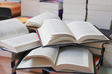 stack of books, close up. Open book on the table in library. Back to school concept.
