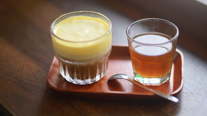 egg coffee with smooth yellow egg cream and small cup of tea