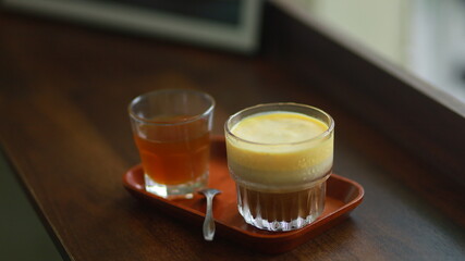 a cup of egg cream coffee and a glass of water next to it