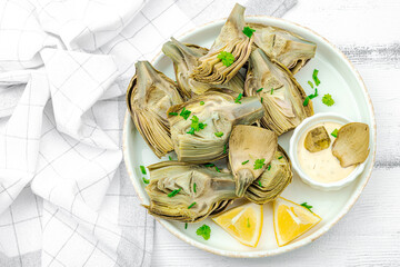 Traditional italian artichoke «alla romana», cooked carciofi vegetable. Olive oil, garlic, parsley