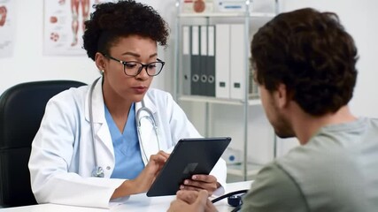 Female doctor using digital tablet and blood pressure gauge checked to consults with young man patients on medical visit at clinic or hospital, Healthcare medical exam concept  - Powered by Adobe