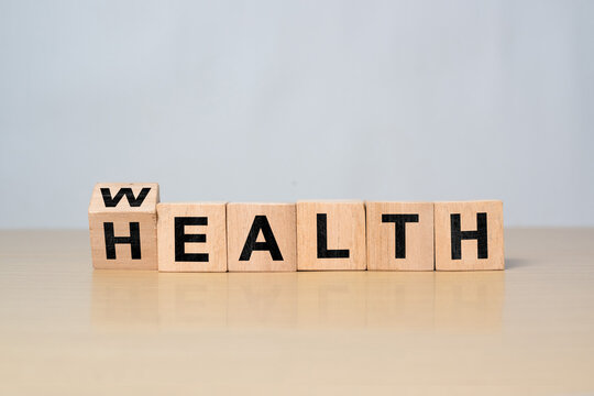 Wooden block turning from Wealth to Health. Symbolic illustration of life insurance, healthcare planning, and smart financial decisions
