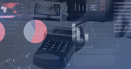 Hand holding banknote over payment terminal at office desk, with financial charts and smartphone
