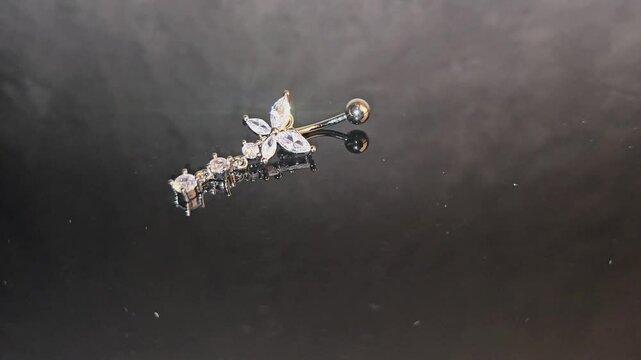 Belly button earrings with stones and a pendant in the shape of cannabis leaves. summer decoration. Piercing