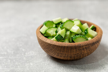 Cucumber on wooden background. Slice of cucumber on background. Fresh organic green cucumbers gherkin. Vegan. Salad ingredient. Farm vegetables. Cut vegetables with knife. Space for text. Copy space