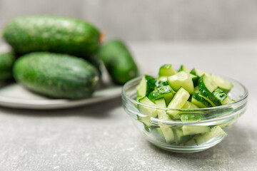 Cucumber on wooden background. Slice of cucumber on background. Fresh organic green cucumbers gherkin. Vegan. Salad ingredient. Farm vegetables. Cut vegetables with knife. Space for text. Copy space