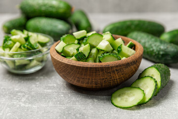 Cucumber on wooden background. Slice of cucumber on background. Fresh organic green cucumbers gherkin. Vegan. Salad ingredient. Farm vegetables. Cut vegetables with knife. Space for text. Copy space
