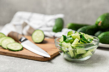 Cucumber on wooden background. Slice of cucumber on background. Fresh organic green cucumbers gherkin. Vegan. Salad ingredient. Farm vegetables. Cut vegetables with knife. Space for text. Copy space