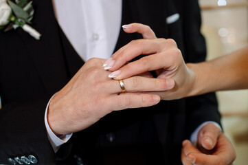 Wedding day. Bride and groom putting wedding rings on each other during the wedding ceremony. Close-up of hands