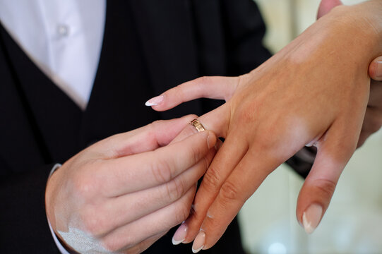 Wedding day. Bride and groom putting wedding rings on each other during the wedding ceremony. Close-up of hands