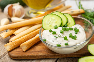 Cucumber sour cream tzatziki sauce on a wooden table.Tartar sauce. Traditional delicious appetizer. yogurt sauce. Tzatziki with ingredients cucumber, garlic,dill,lemon,mint. salad dressing.Copy space