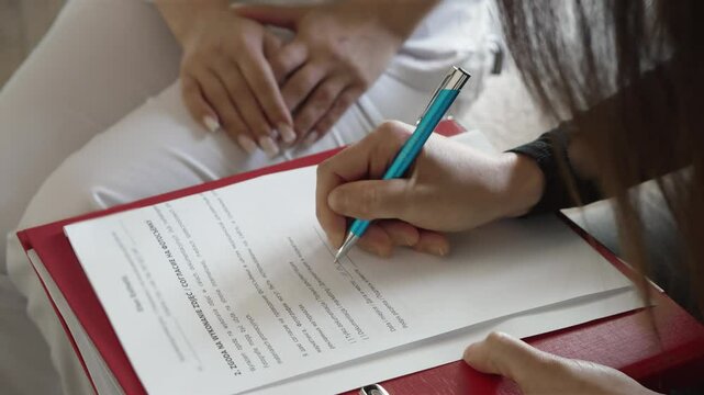 Woman patient consulting cosmetologist for filling document. Female client discussing medical form with beauty specialist. Patient talking to skincare professional about completing paperwork