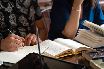 Book club members taking notes and reading in cafe