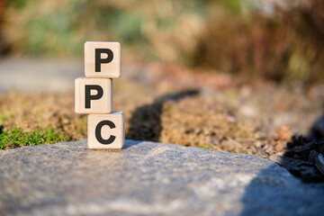 PPC - concept text on cubes standing on a stone on a natural background