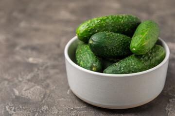 Cucumber on wooden background. Slice of cucumber on background. Fresh organic green cucumbers gherkin. Vegan. Salad ingredient. Farm vegetables. Cut vegetables with knife. Space for text. Copy space