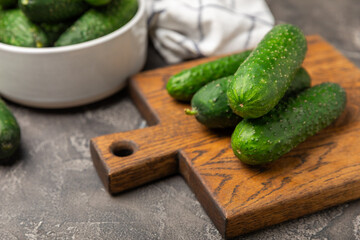 Cucumber on wooden background. Slice of cucumber on background. Fresh organic green cucumbers gherkin. Vegan. Salad ingredient. Farm vegetables. Cut vegetables with knife. Space for text. Copy space